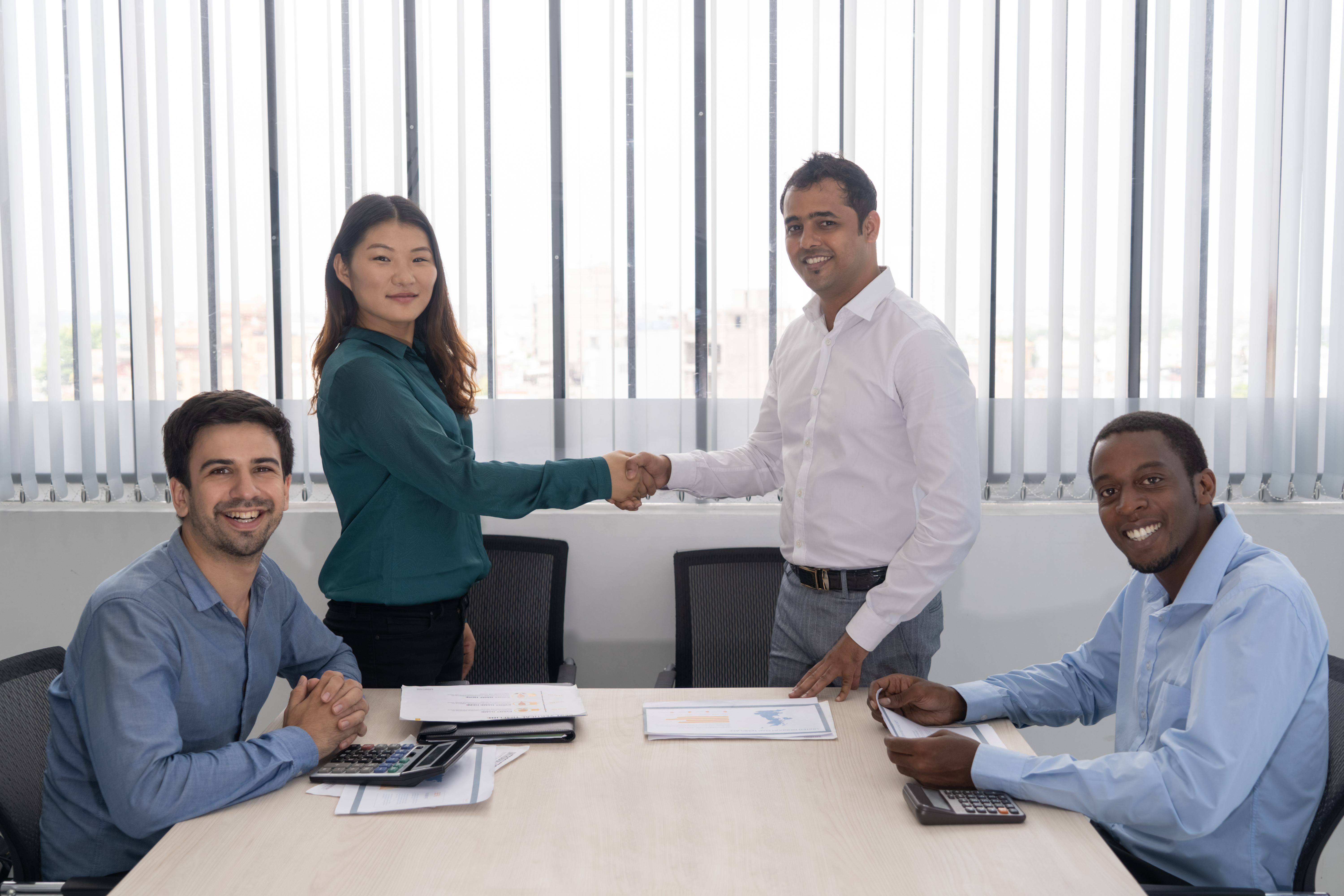 Colleagues smiling and interacting in a collaborative workspace